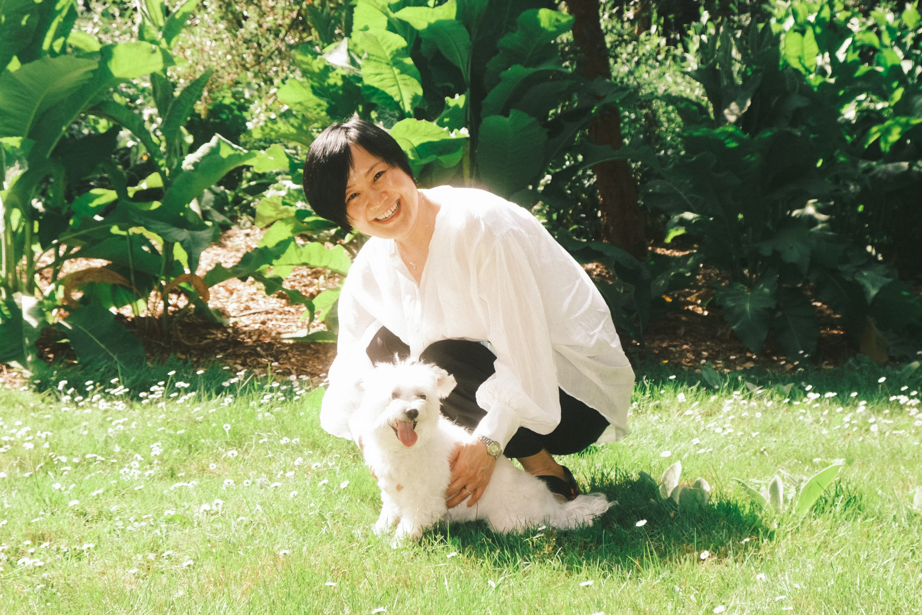 Hanara's mom kneeling on grass with Thor the dog
